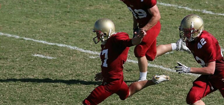 Three football players running on the field