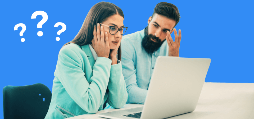 A man and a woman sitting behind a laptop looking confused and frustrated.