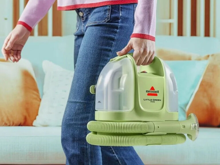 woman holding a bissell green machine